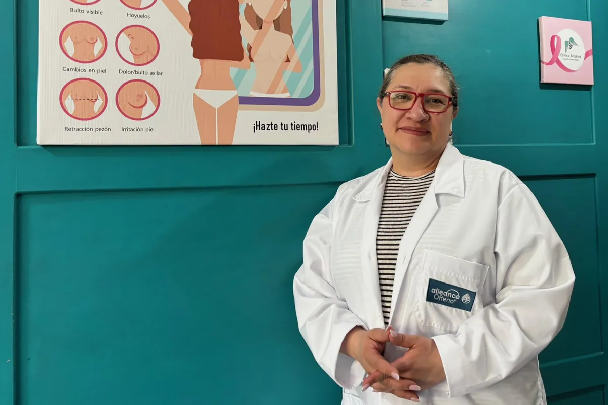 Radióloga de Clínica Ángeles junto al cartel de detección